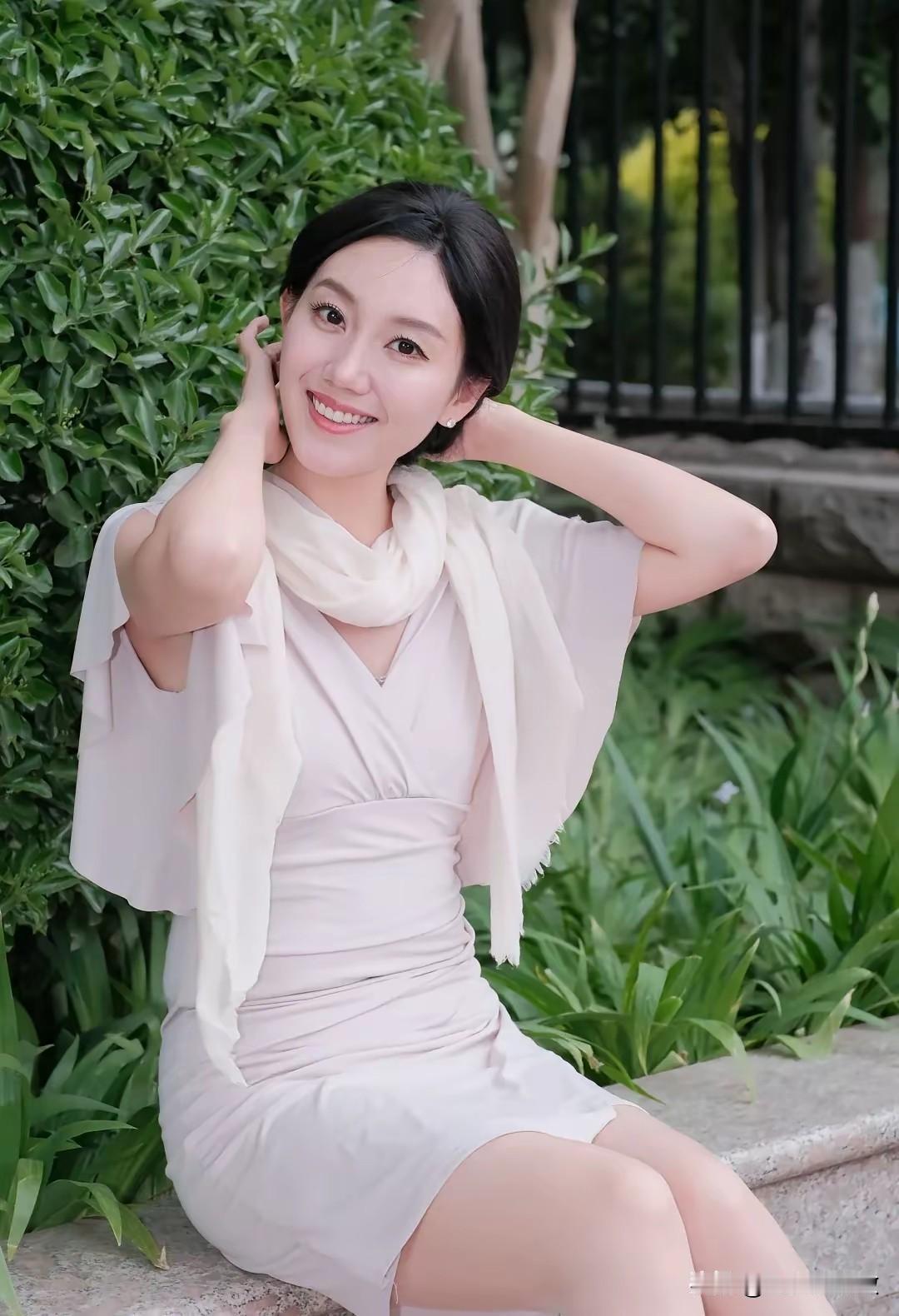 微笑的女士坐在绿植旁。