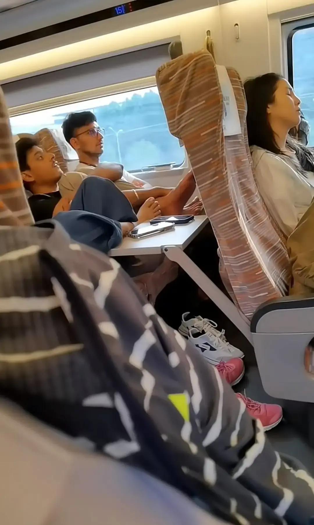 坐高铁的2个印度人把光脚跷到前面小桌板上了，脚丫子就搁那儿明晃晃摆着旁边小姐姐眼