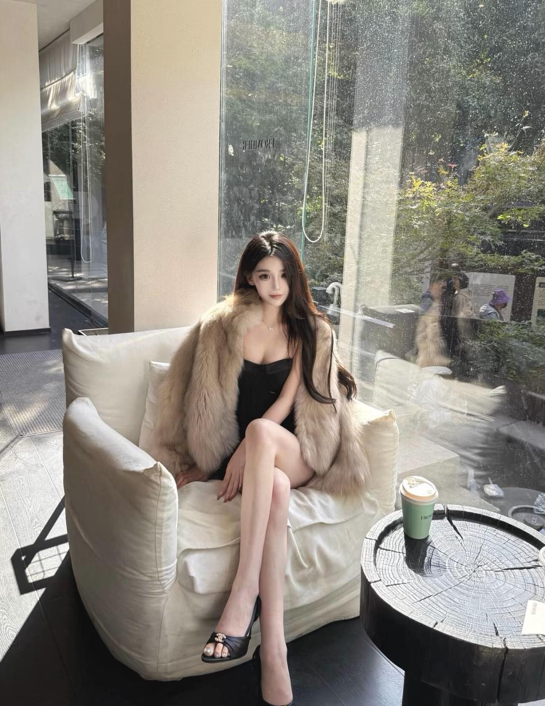 冬日暖阳下的时尚咖啡馆，优雅黑裙与毛绒外套的完美搭配，尽显都市女性的魅力。