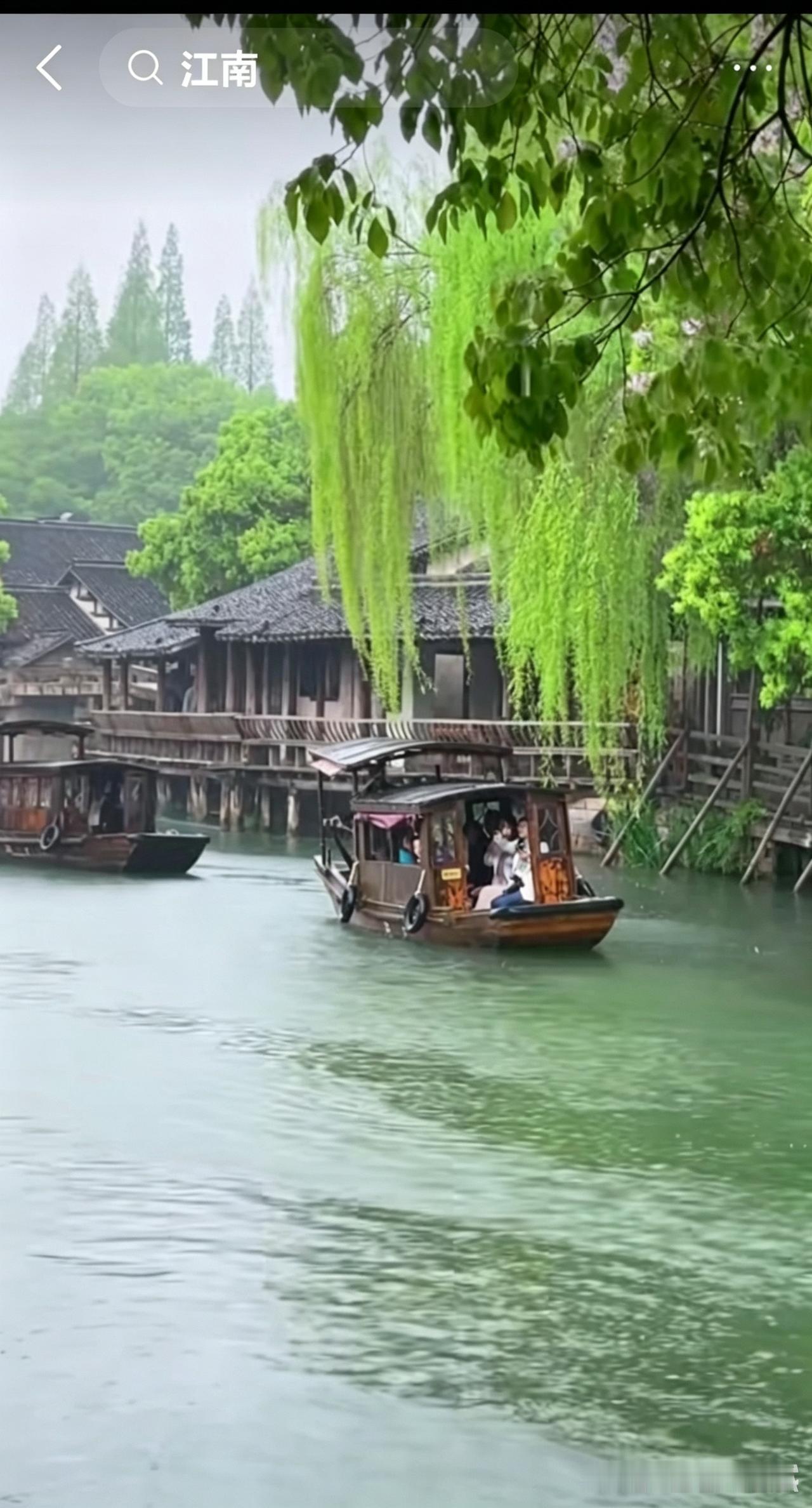江南的雨天生醉人。薄雾笼着两岸翠柳，青瓦木屋临水而立，乌篷船轻轻划过平静河面，水