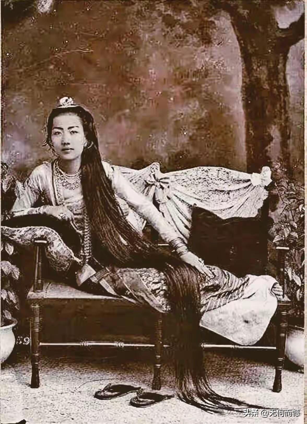 老照片中的这个女子的头发真是够长的了，从床上一直拖到地上，目测头发比她的身高还要