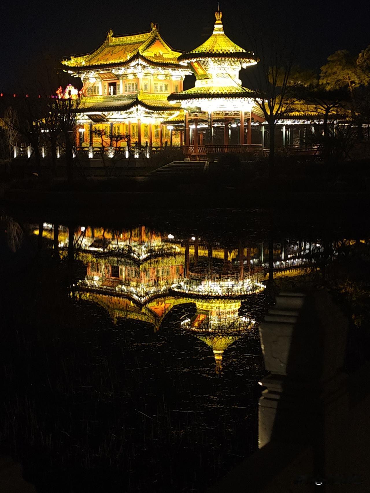 《晋阳夜影》

檐角挑星水接天，
灯痕碎作玉鳞连。
唐风未老凭谁问，
半入清波半