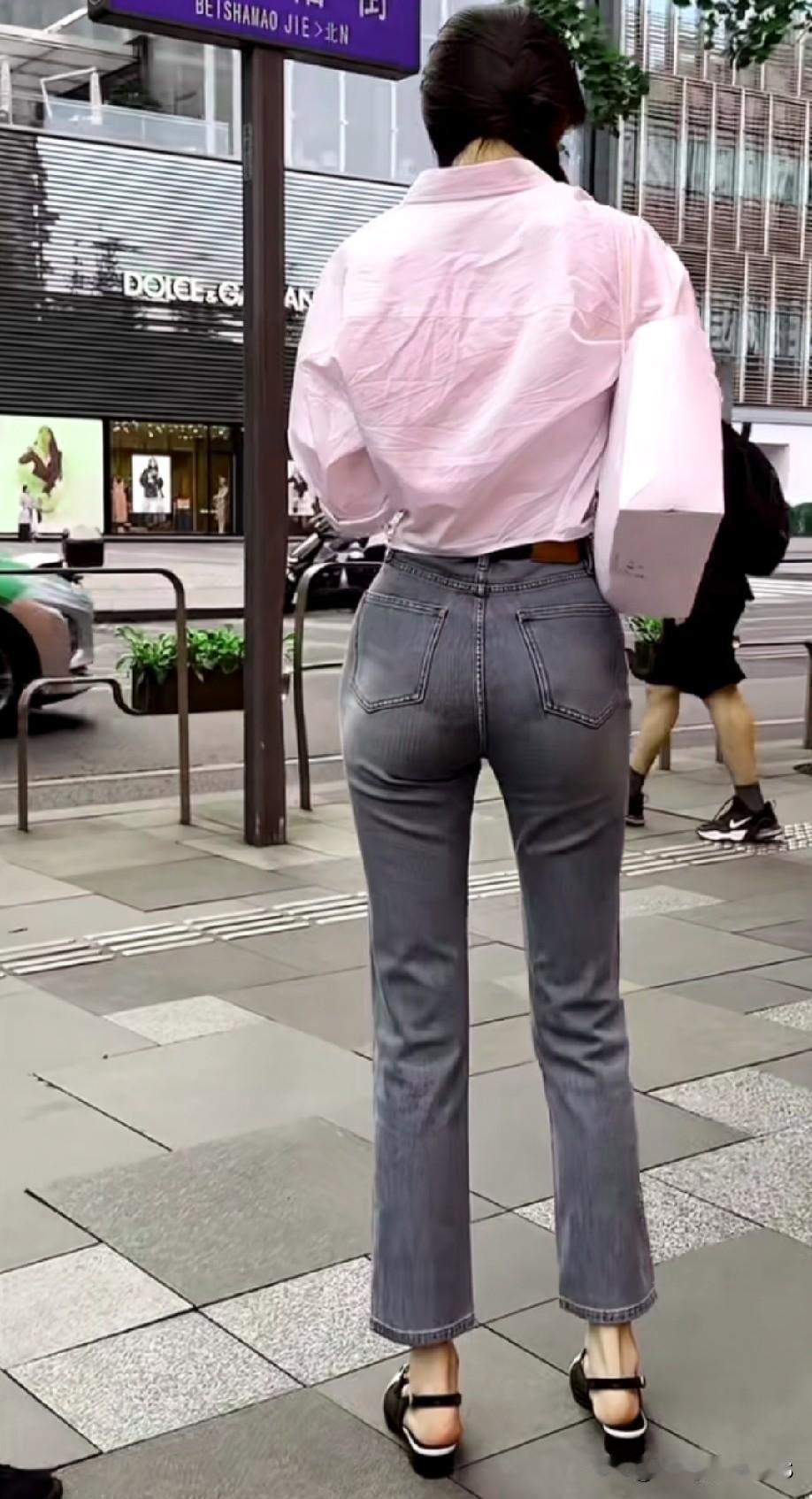 在北京北纱帽街的街头，我偶然邂逅了这位小姐姐。她身着浅粉色衬衫，搭配灰色牛仔裤，