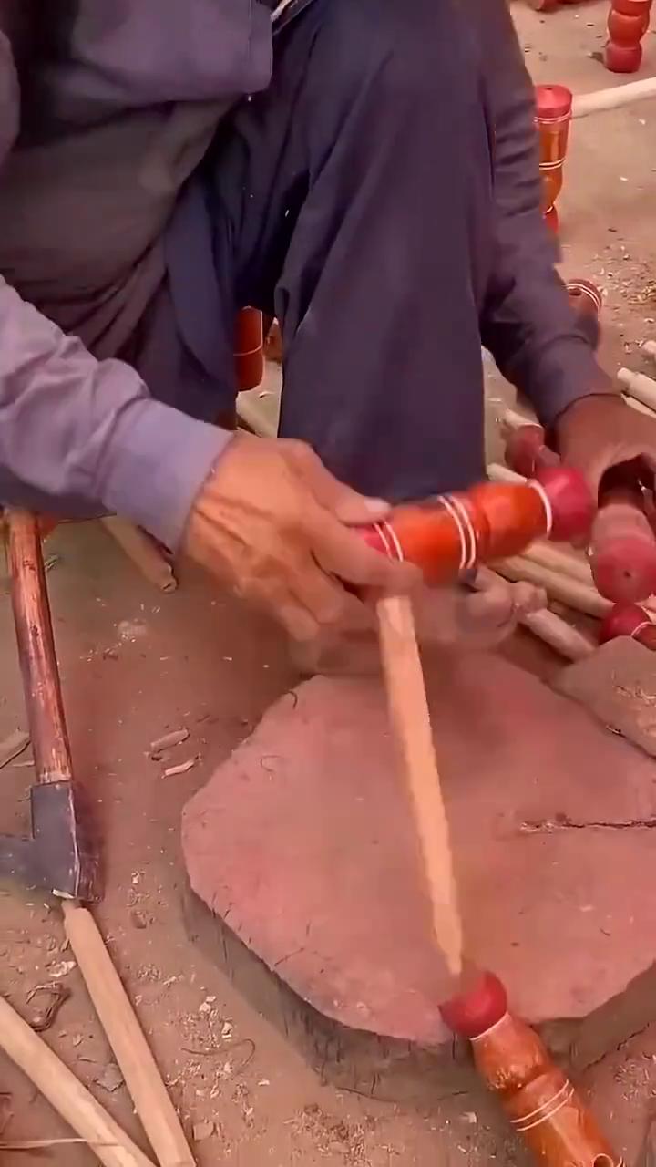 看看这大叔组装什么？是凳子腿吗？还是什么腿？拿木棍一个穿一个的装上，整的挺精致的