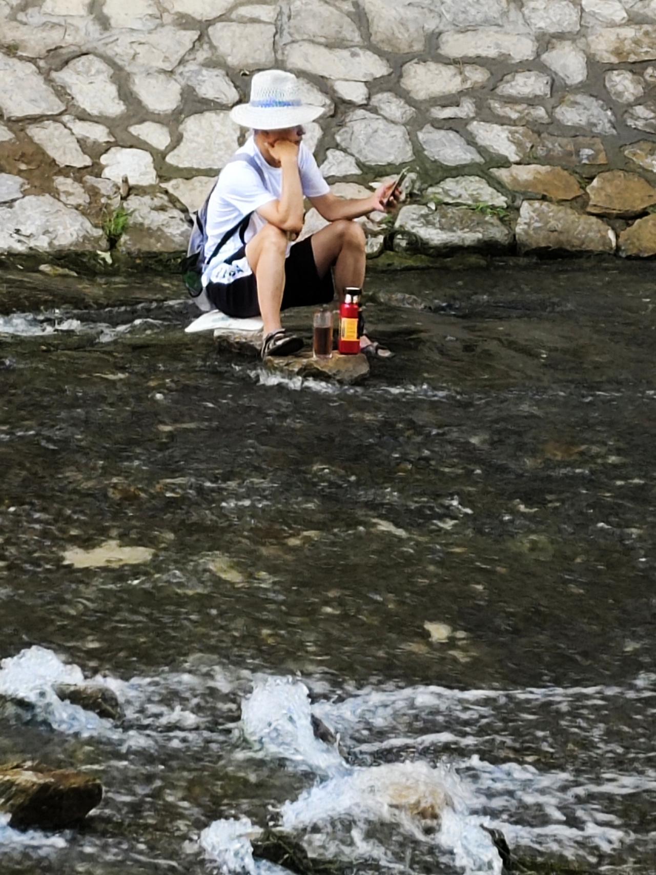 酷暑难耐的天，瞧瞧，这人真会找凉快地方避暑！大桥下，水库的水哗啦啦地唱着欢快的歌