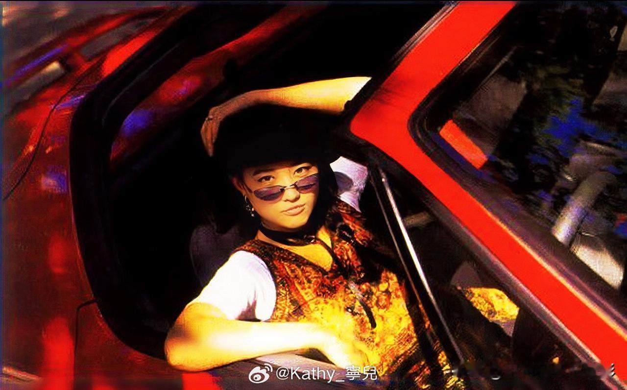 🧡港星女神周海媚
红跑车往那儿一靠
花背心配黑帽子
抬手拢帽檐那一下
阳光裹着