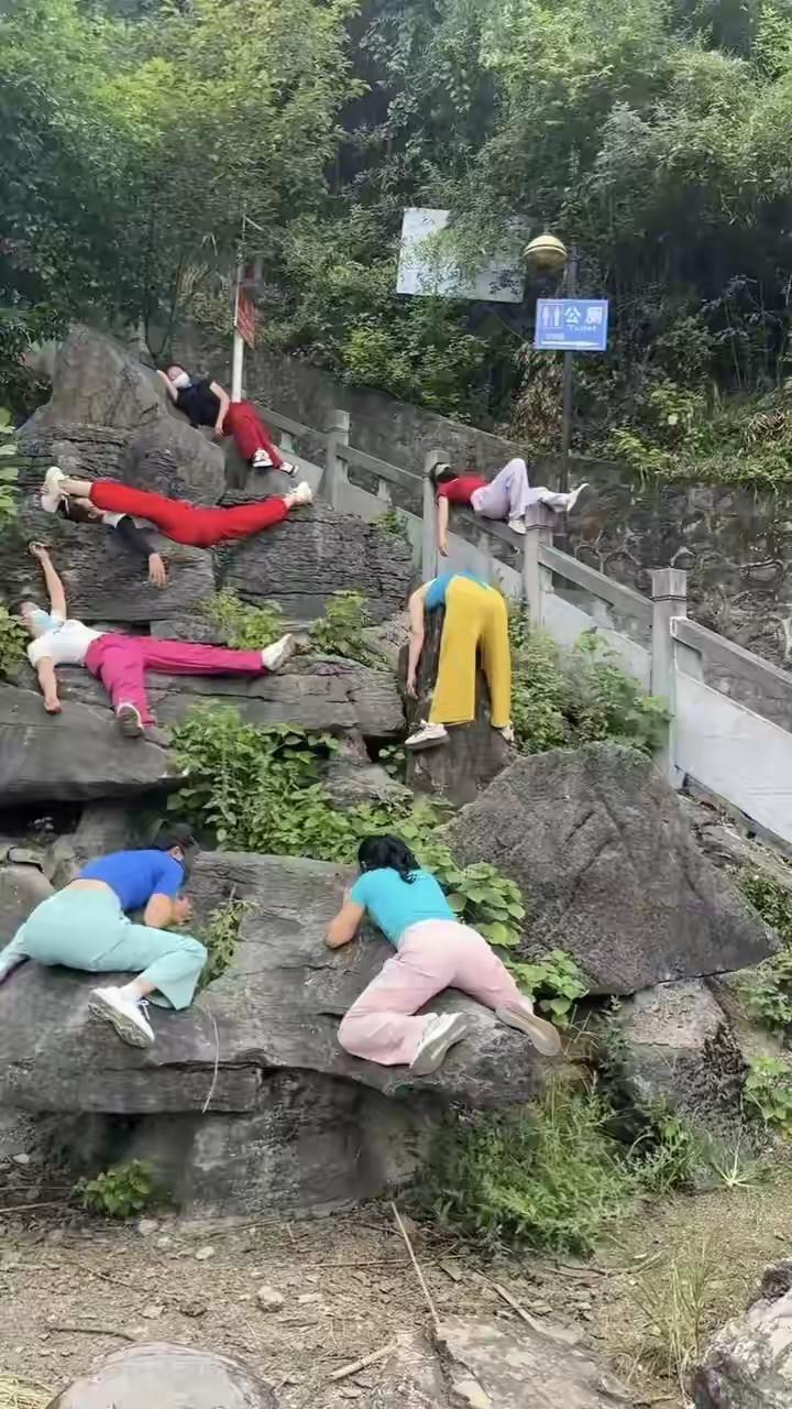 大家帮忙分析一下，这些人在干什么嘛。一大帮人躺在旅游景点，是走累了在休息呢，还是