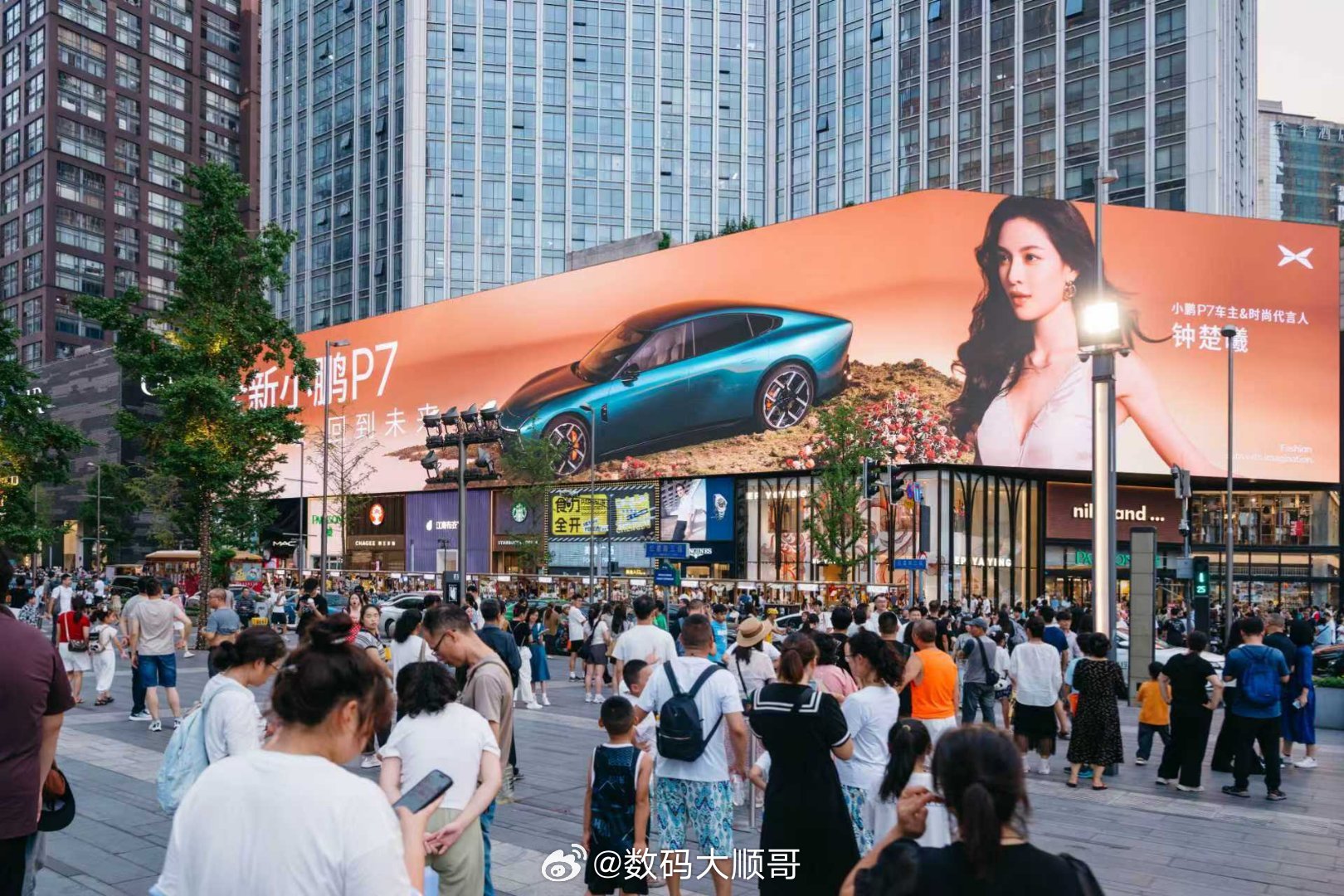 钟楚曦与全新小鹏P7共同出现在成都春熙路的广告大屏。作为一款定位时尚的豪华轿跑，