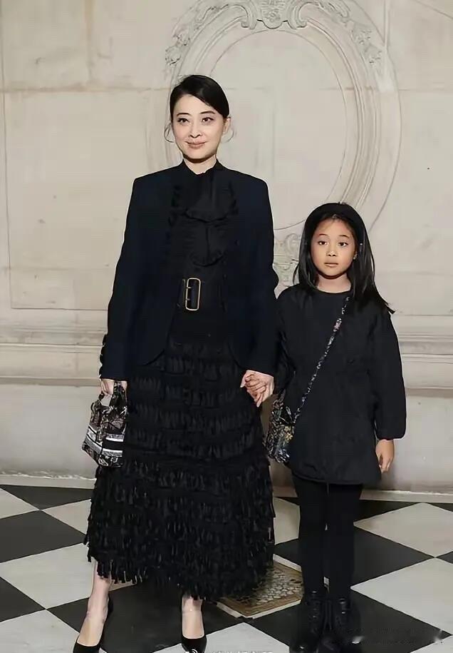 梅婷的女儿跟妈妈穿一个色系的衣服，长得跟妈妈好像，小女儿可爱大方，以后长大了会成