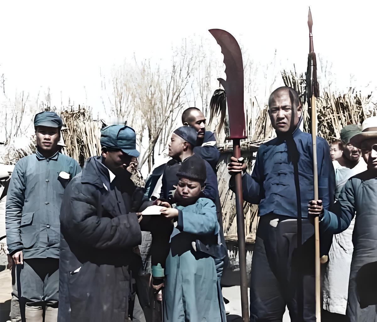 抗战时期的华北根据地，一群民兵和干部凑在土场子上。戴军帽的干部正弯腰，跟个小娃对