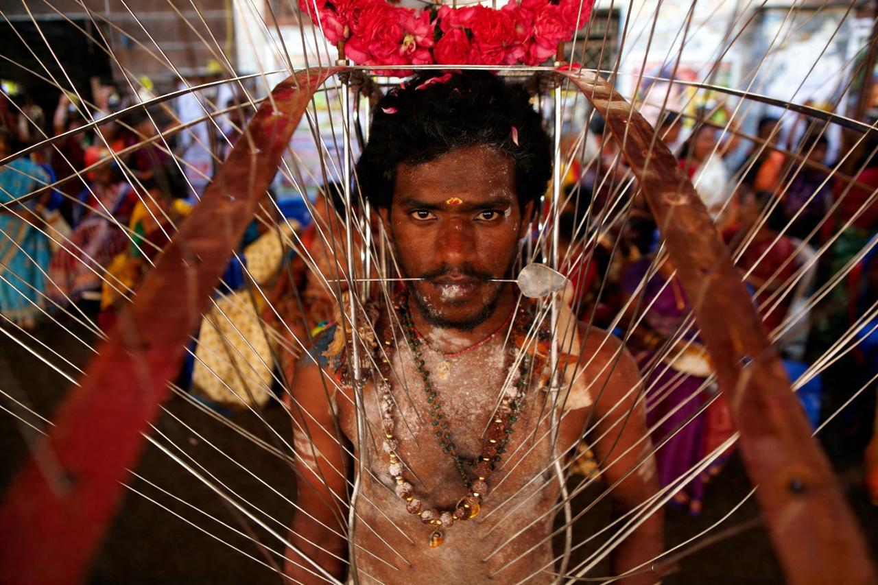 这是2013年印度钦奈的一名印度教参与苦行的信徒将身上插满铁钎参加盘古尼尤素姆节