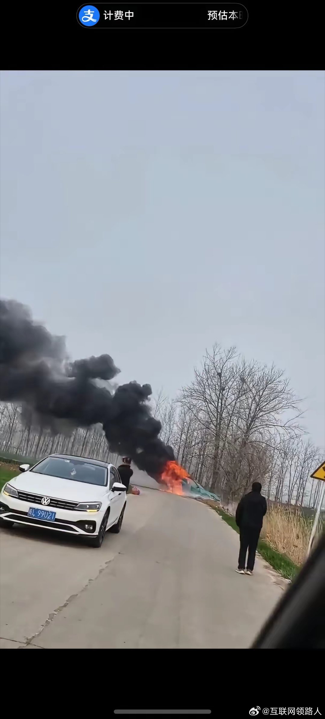 刚刚刷手机，又刷到一辆绿色轿车起火的视频。画面里，车辆已冲出道路，右侧车门敞开着