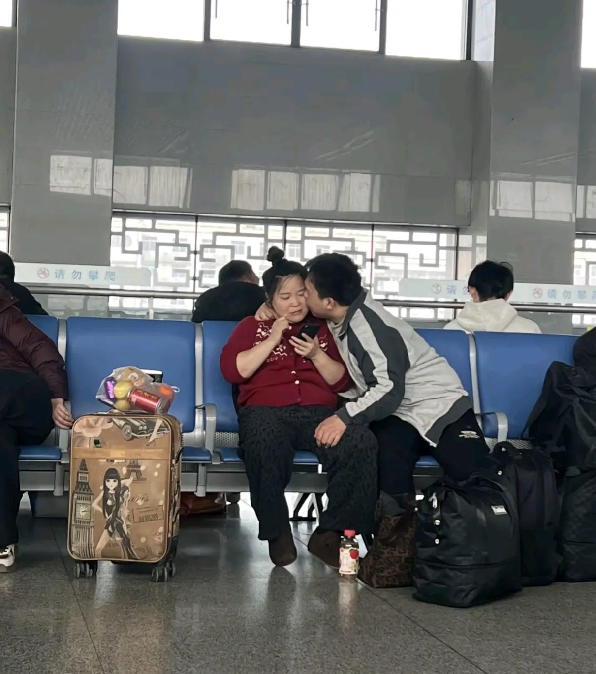 这男人得多爱自己的老婆，也不是小年青了，大庭广众之下，候车的间隙也要秀恩爱。