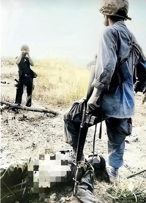 1972年，战场上躺着一个越南女兵的尸体，旁边的美国士兵先是扯下她的裤子，再翻起