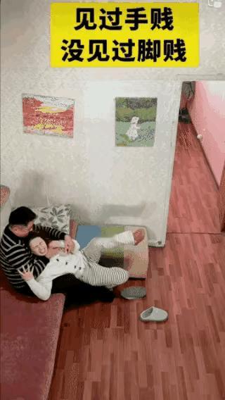 一女子和男子开玩笑
把穿着袜子的脚伸到男子嘴边，男子一把将女子的袜子拽下，将女子