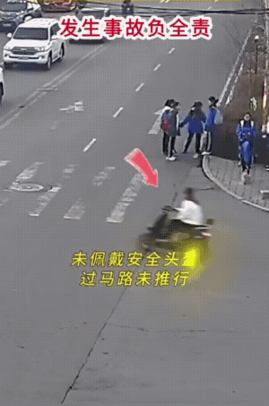 他不仅横穿马路(没走斑马线)，皆有可能还是闯了红灯。
骑着电动车不戴头盔不说，还