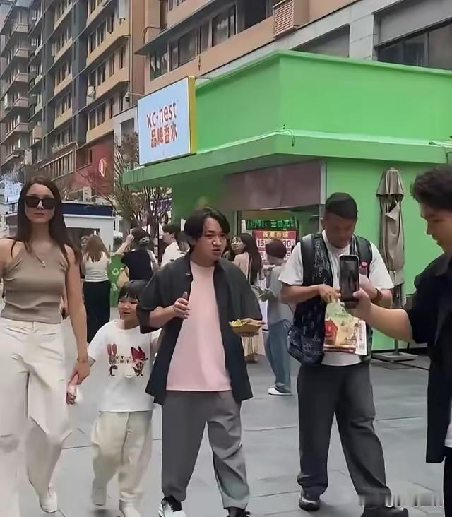 45岁王祖蓝带着妻女在贵州游玩，还品尝当地特色炸草蜢。路人拍到一家三口逛街，大女