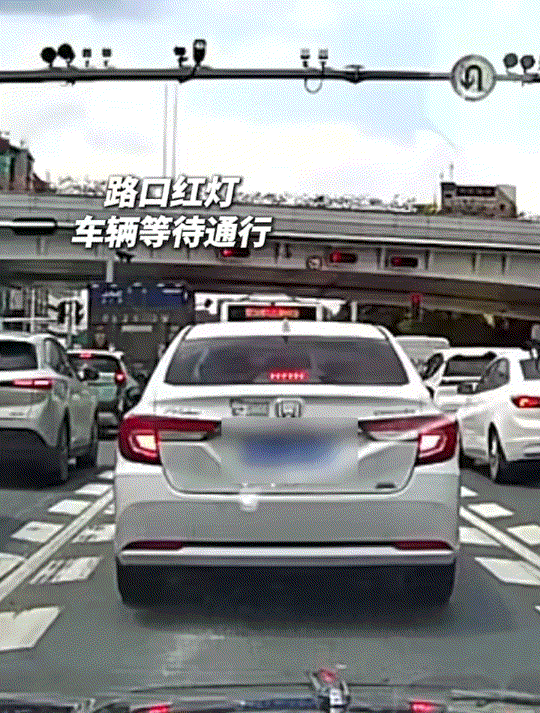 差点就没命了！广东一马路上，一男子骑电动车载人横穿在等待红绿灯的车流里，并将车子