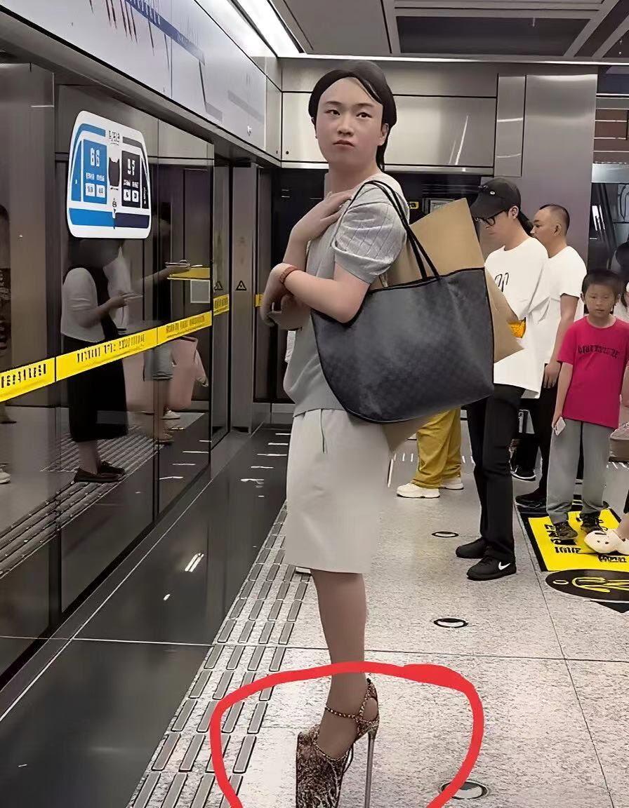 身穿裙子，手提购物袋，在拥挤的地铁站台上等候时，恨天高高跟鞋，鞋跟又细又高。
一