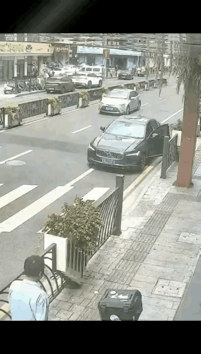 路边停着一辆黑色小轿车，司机停车后完全不看后方路况，直接拉开车门。后方一辆三轮车