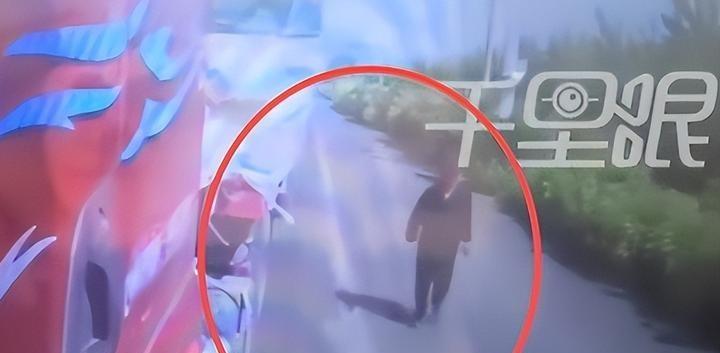 路灯的昏黄被水幕冲刷得迷离。开车经过时，我下意识地踩住了刹车。路边屋檐下，缩着一