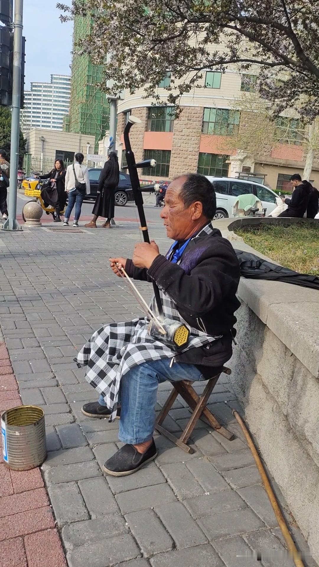 助      残
下午三点多，乘公交车去玉渊潭公园看樱花。一下车，隐约听见有拉二