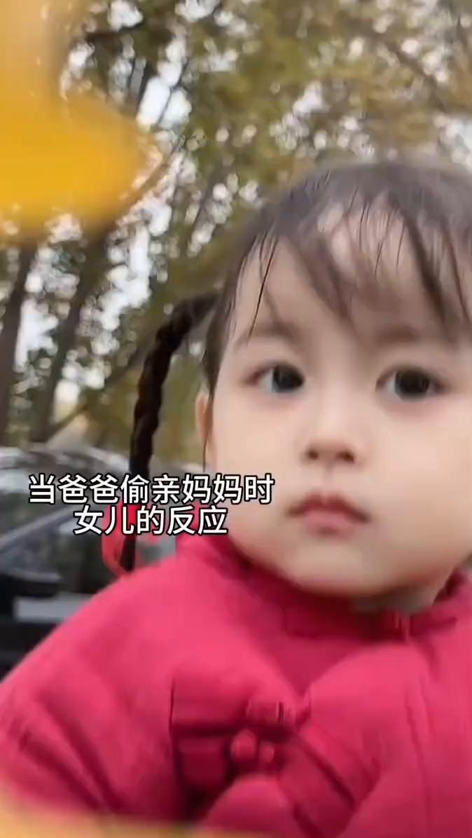 当爸爸偷亲妈妈时女儿的反应。