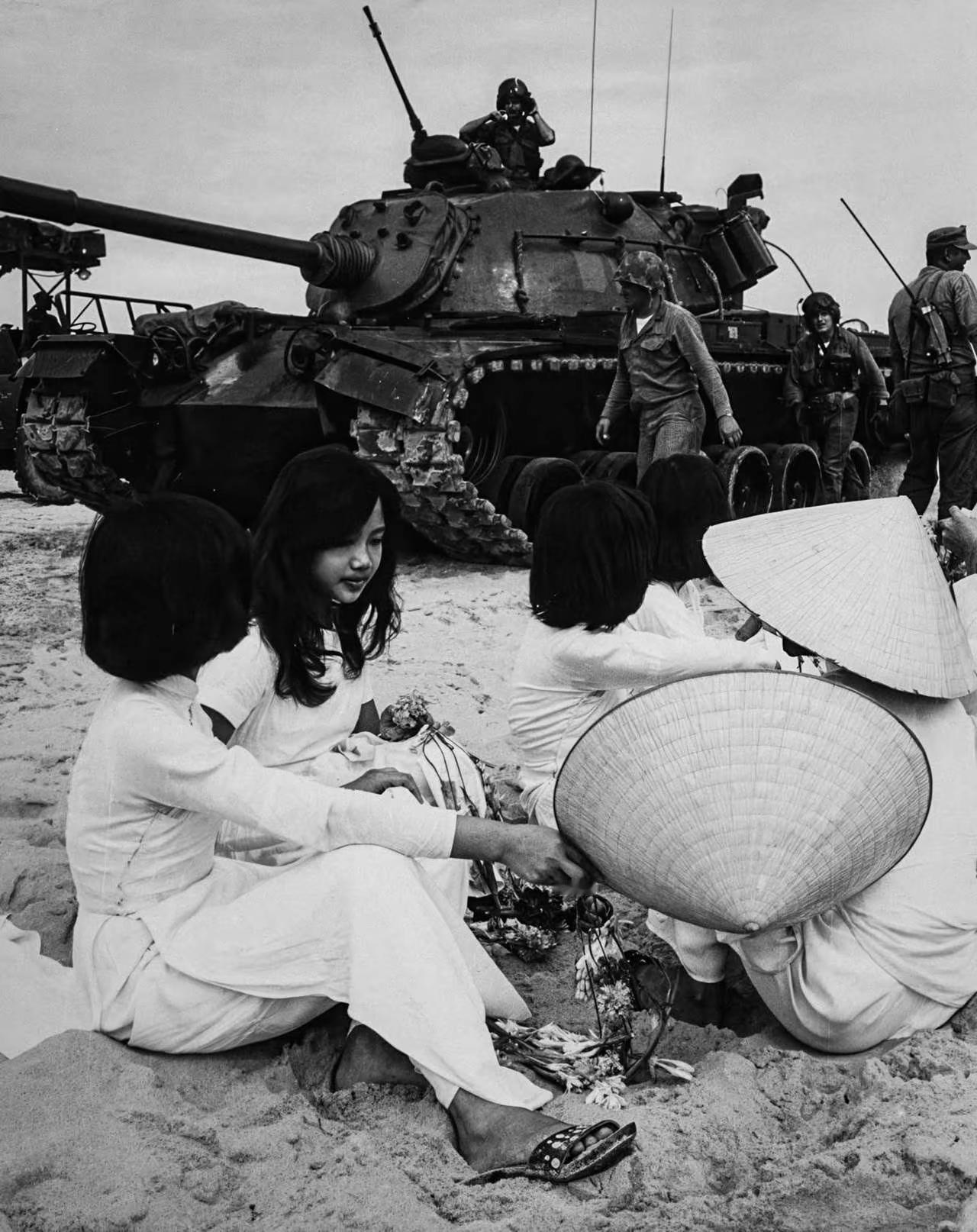 图一为：越战期间（1965年5月初），坐在沙滩上的越南献花女郎！（相关内容评论区