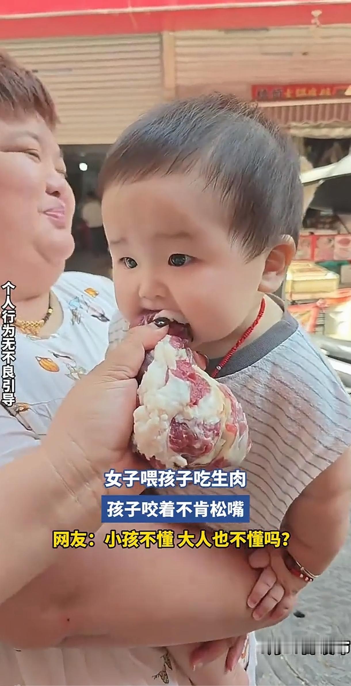 一女子用生肉喂小孩，抱着小孩的人还一个劲的笑，哪里是逗小孩啊，这是祸害人家孩子。