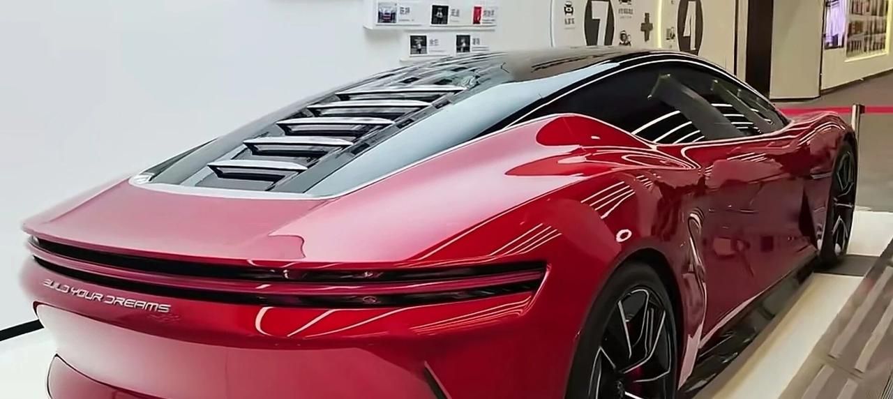 这是比亚迪下一代新款吗？猜一猜一辆停放在比亚迪展示台的红色轿车，流畅的溜背造型，