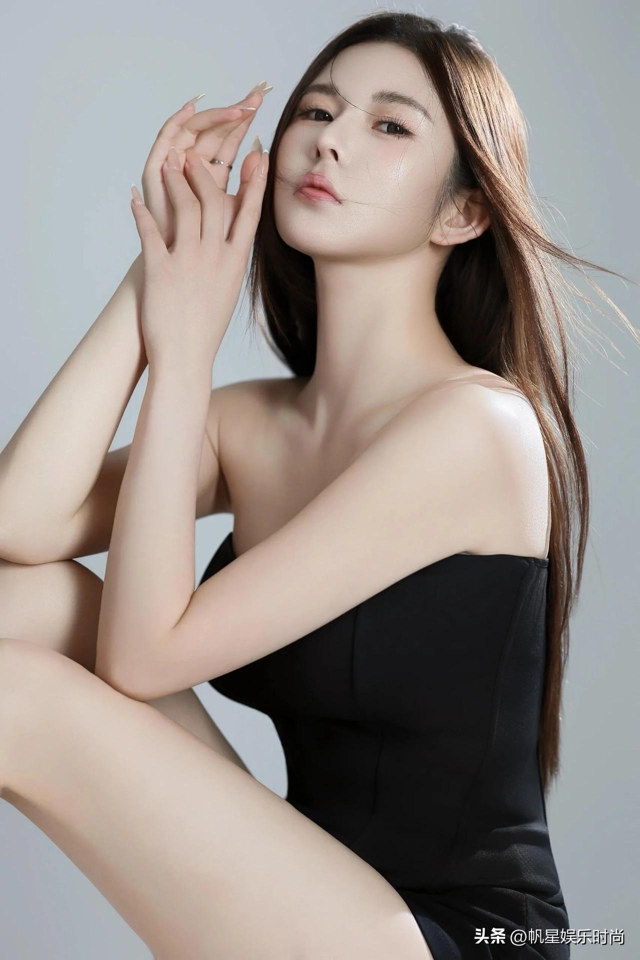 身着黑色抹胸连体短裤，风格简约而不失性感。抹胸的设计巧妙地展露了肩颈线条，贴合身