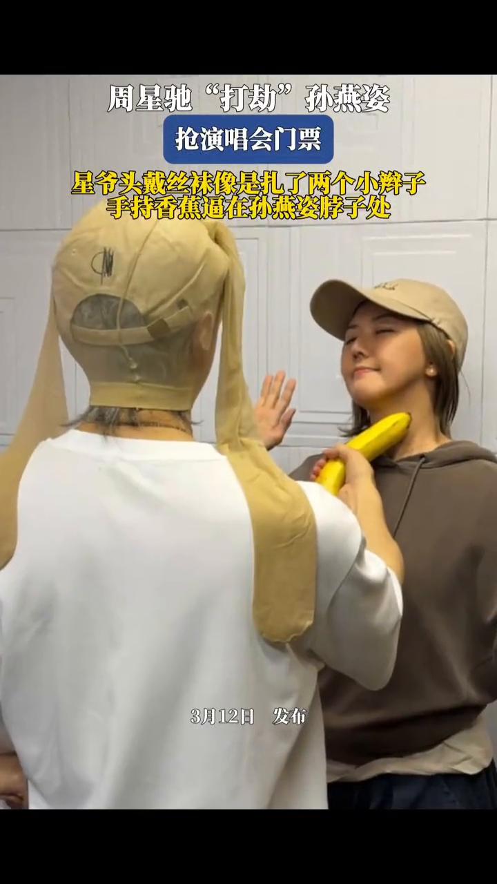 周星驰"打劫"孙燕姿抢演唱会门票。
星爷头戴丝袜像是扎了两个小辫子，手持香蕉逼在