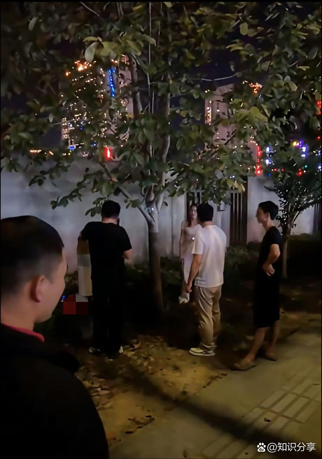 妻子出轨被当场抓现行，丈夫小区树下“算账”引众人围观。

夜晚一小区树下的一幕，