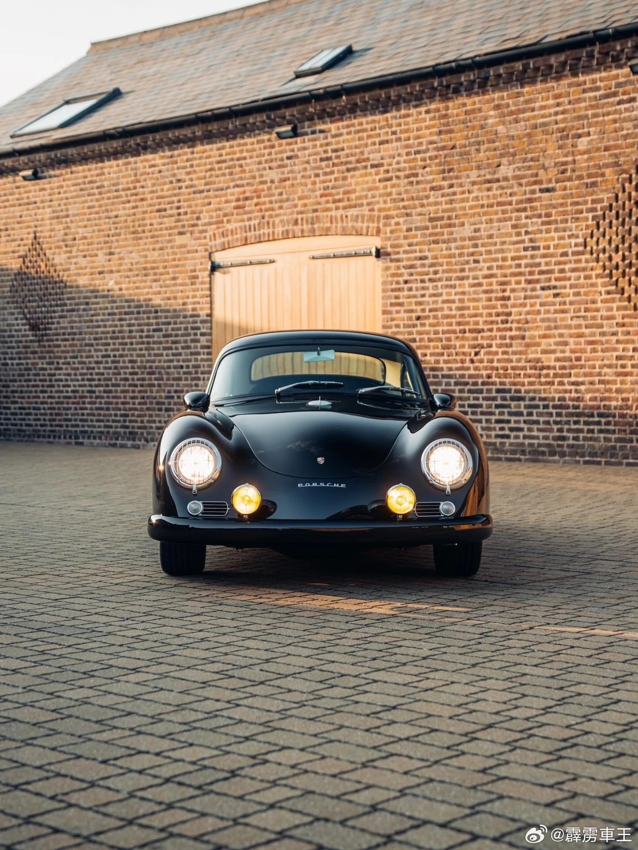 黑色保时捷356 静静停在砖墙边，像琴酒藏起的温柔一面。经典蛙眼灯暖光流转，圆润