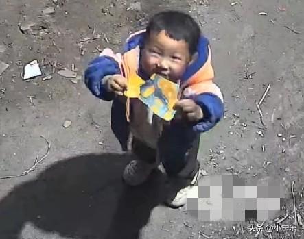 近日，河南商丘一4岁男孩站在家中的监控前，努力举起一个玩具包装纸，对着监控镜头喊