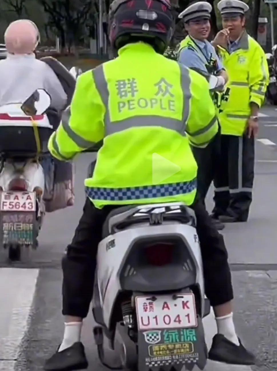 江西南昌街头惊现交警同款反光制服，只不过后面写的不是“警察”和police，而是