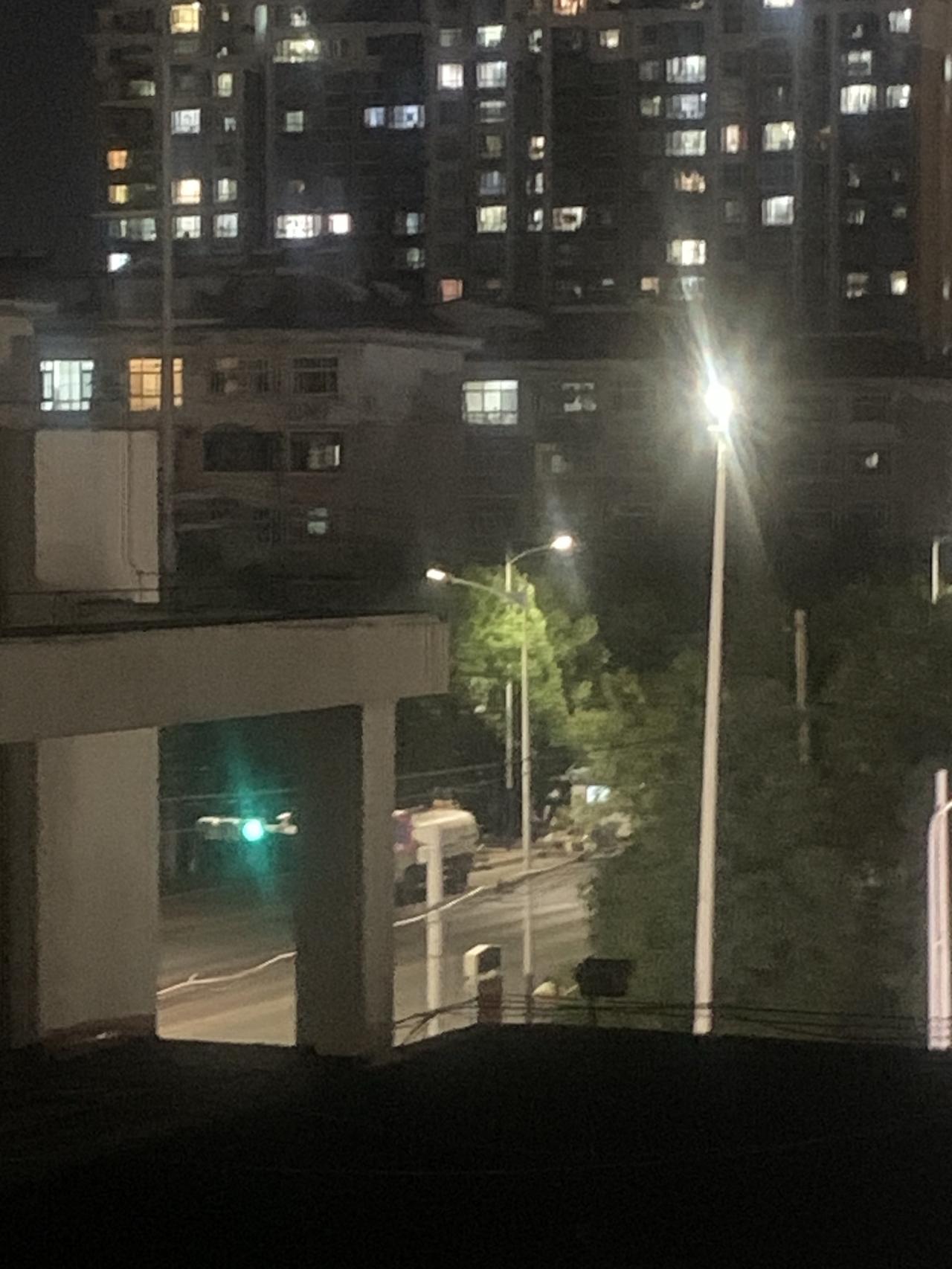 晚上九点，居民楼亮起万家灯火。窗格里的光，有的暖黄，有的冷白，像城市的心跳，安静