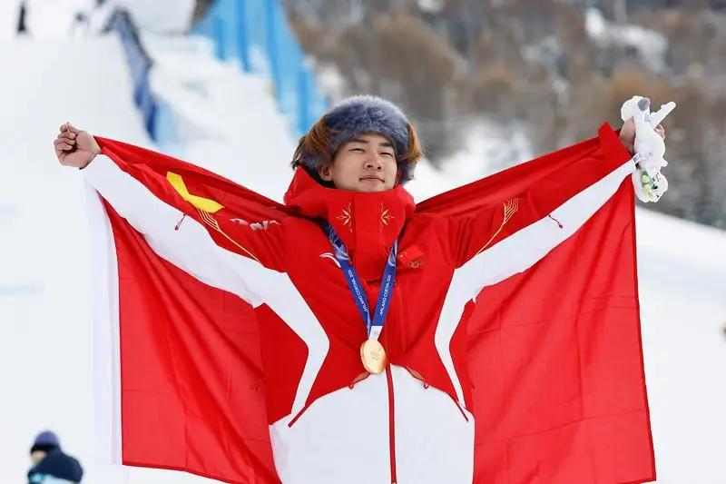 国旗披肩上，他哭得像个孩子。但你仔细看，那眼泪里，铜的涩味比金的闪光，好像还重那