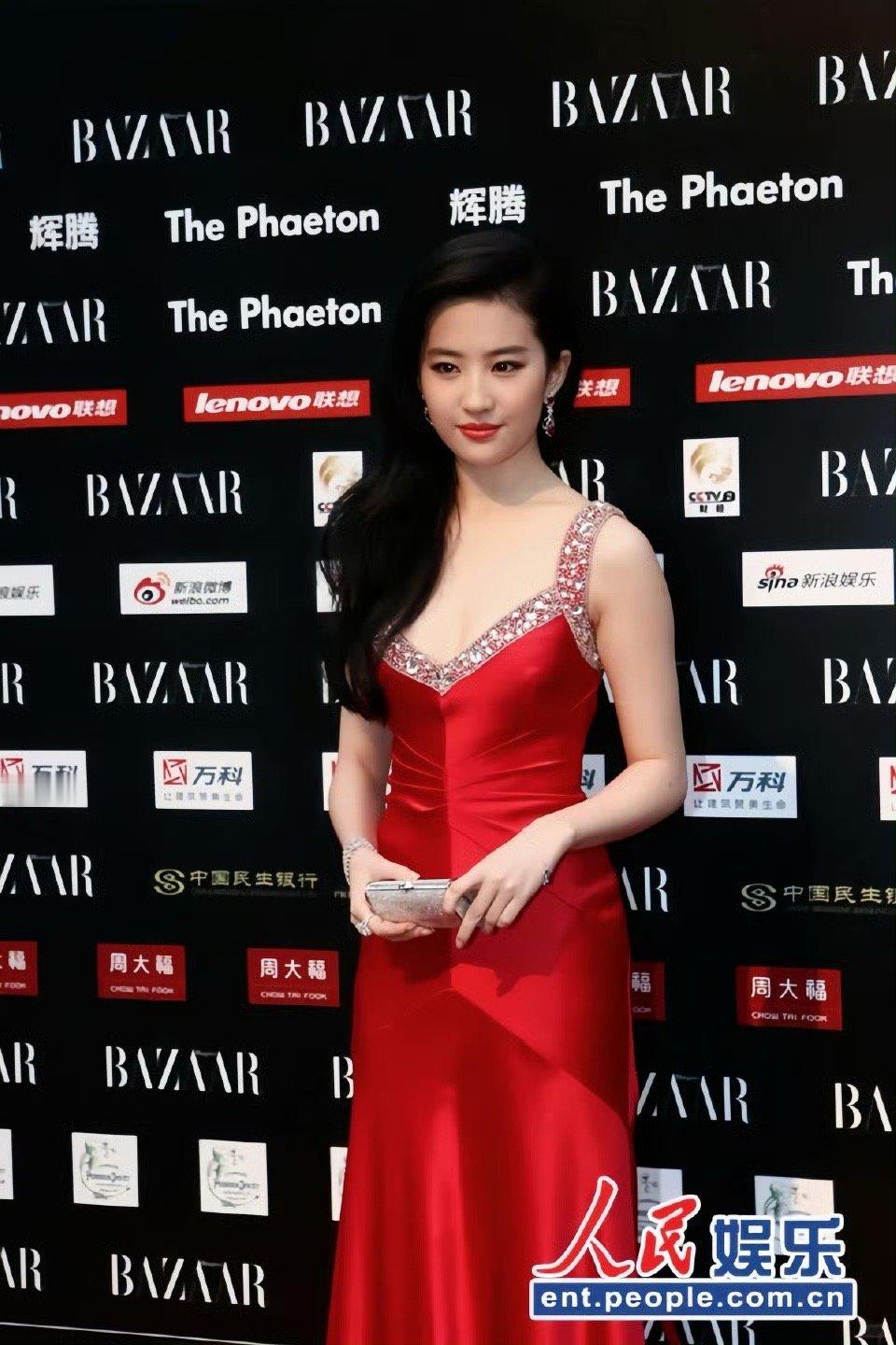 刘亦菲身着红裙亮相，缎面质感衬出优雅气质，闪耀钻饰为造型增色。在芭莎慈善夜背景前