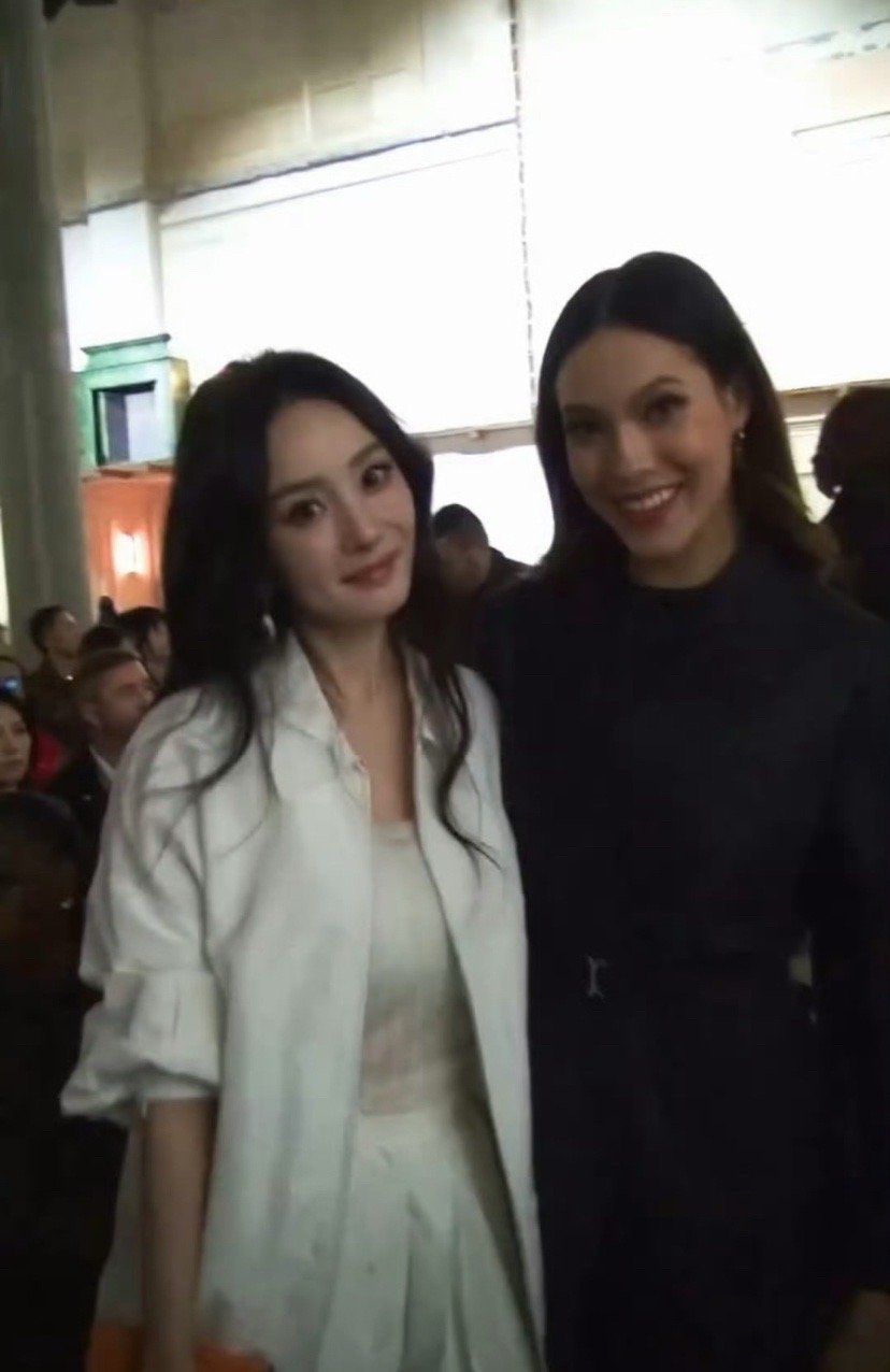 在米兰时装周同框，杨幂一身纯白造型温柔大气，谷爱凌黑色收腰裙干练利落，两位女神同