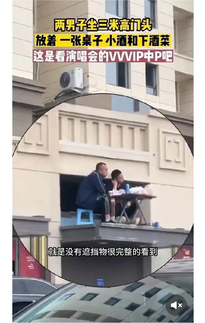 两男子小区门头观赏演唱会，视野开阔，摆小酒桌唠嗑 。 

6月10日，辽宁沈阳某