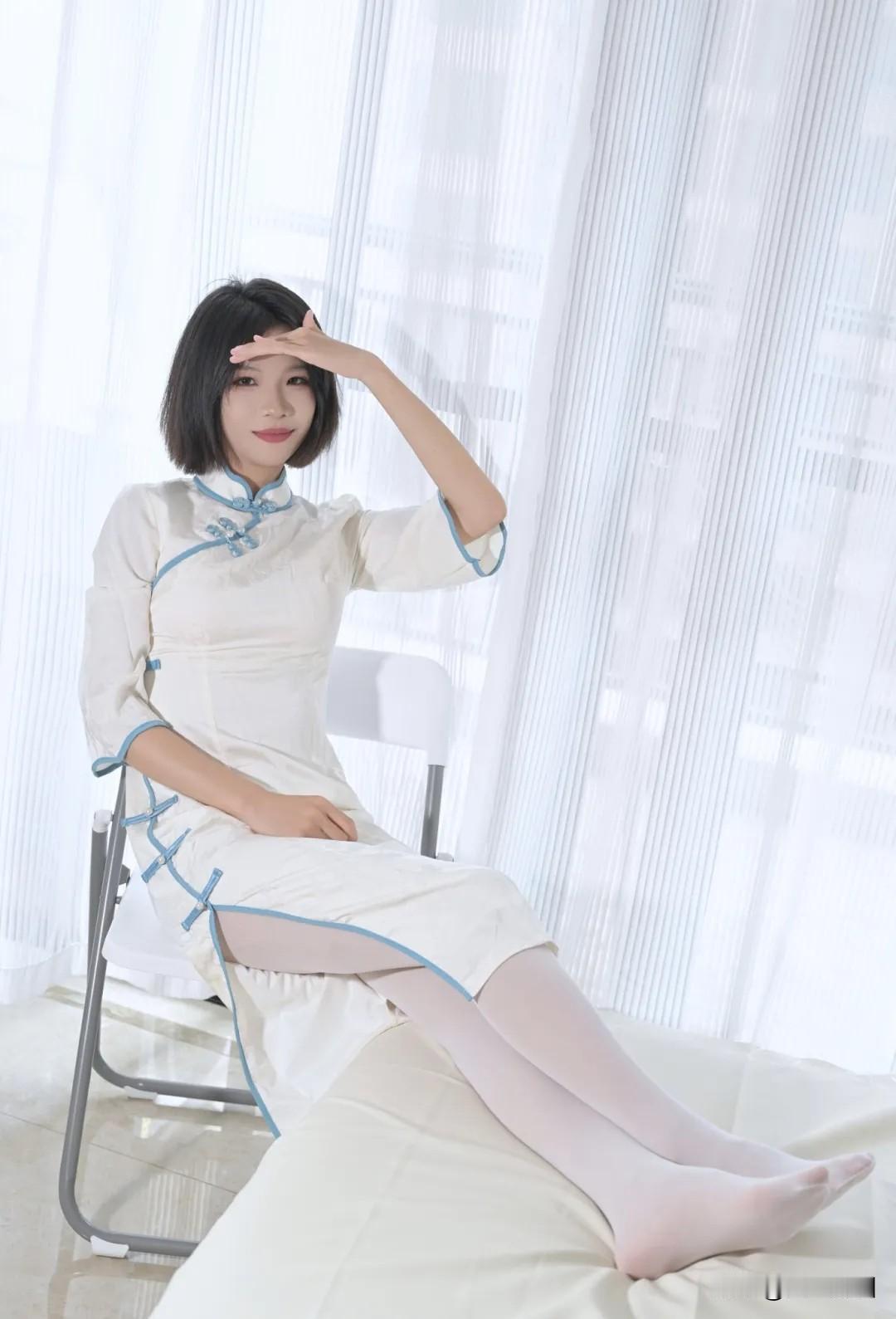 白衣蓝边旗袍，优雅气质满满，坐在窗边，阳光洒落，温柔如水。