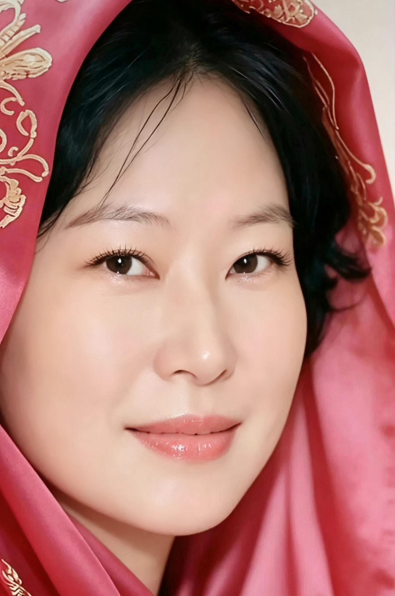 这位美女穿着红色的头巾，微笑得很迷人。
