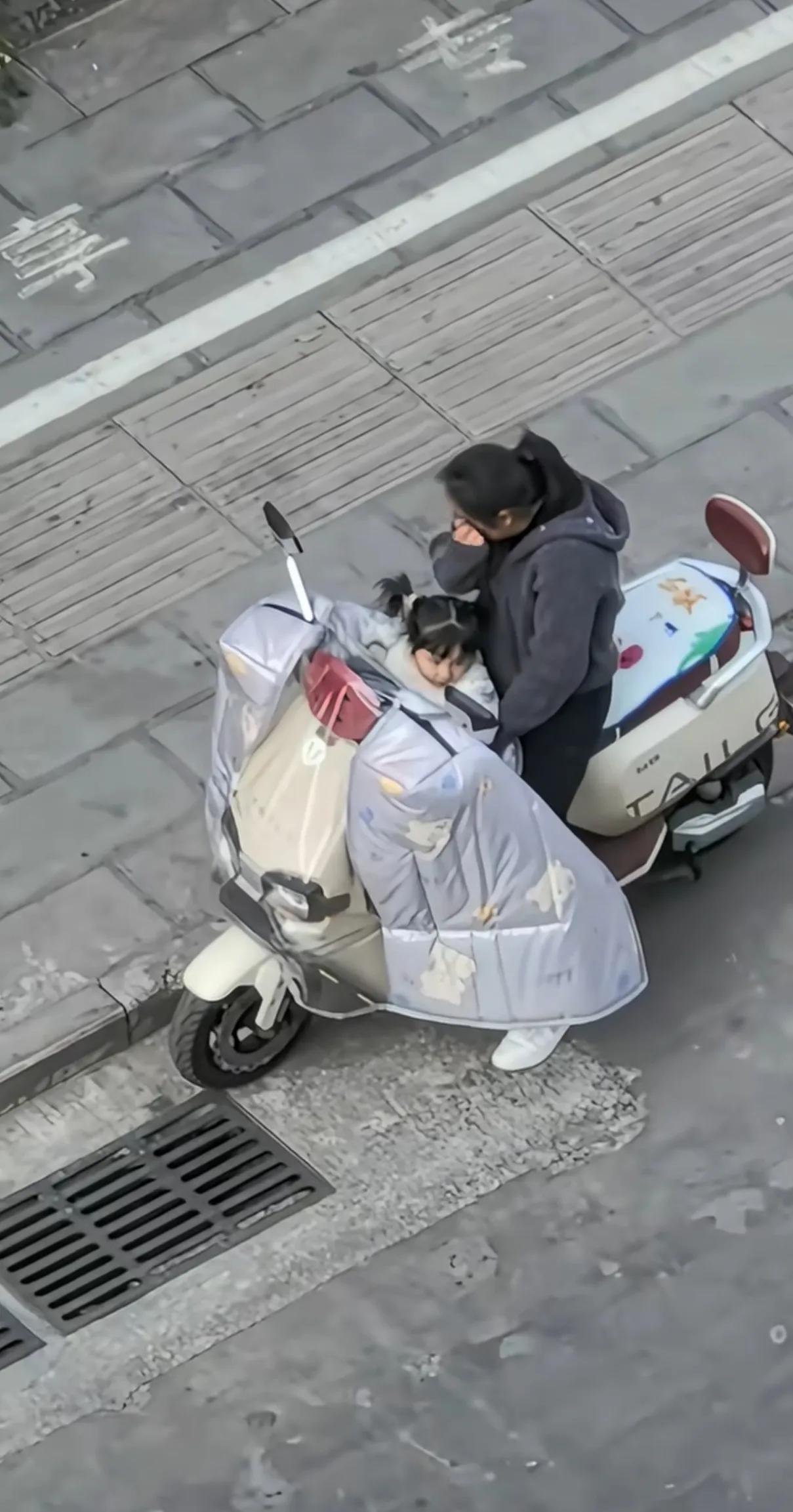 女子骑车带着孩子，停路边崩溃大哭，后面骑黄色车的黑衣男子停车询问她，她哭的更伤心