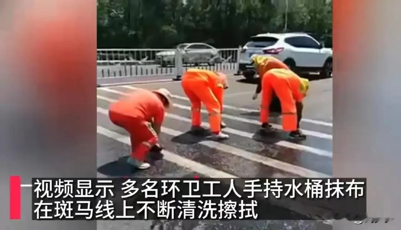 辽宁大连，在高温天气下，一群环卫工人身穿长袖工服，冒着酷暑，拿着抹布和钢丝球，蹲
