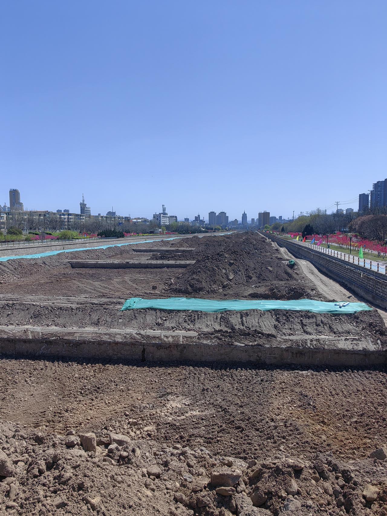 从这里望去，工程的规模颇为宏大。相信建成之后，定是千秋功业。河道里的淤泥或许未曾