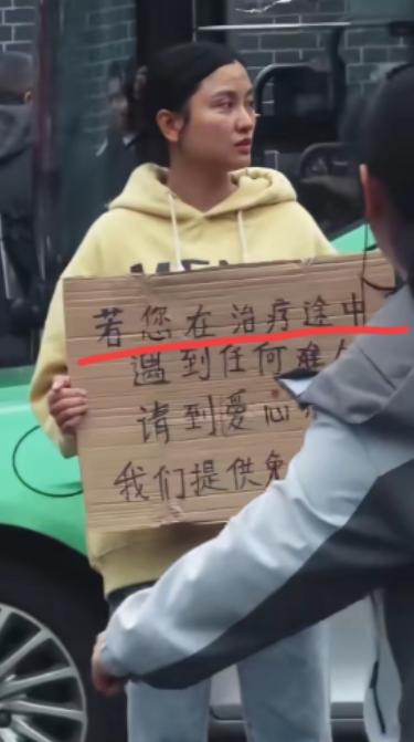 四川成都，华西医院门口有一个女孩子胸前举着一块牌子，写着提供免费住宿吃饭，很多人