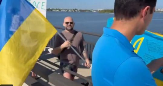 人们挥舞着乌克兰国旗聚集在通往海湖庄园的桥上，表达他们对弗拉基米尔·泽连斯基的支