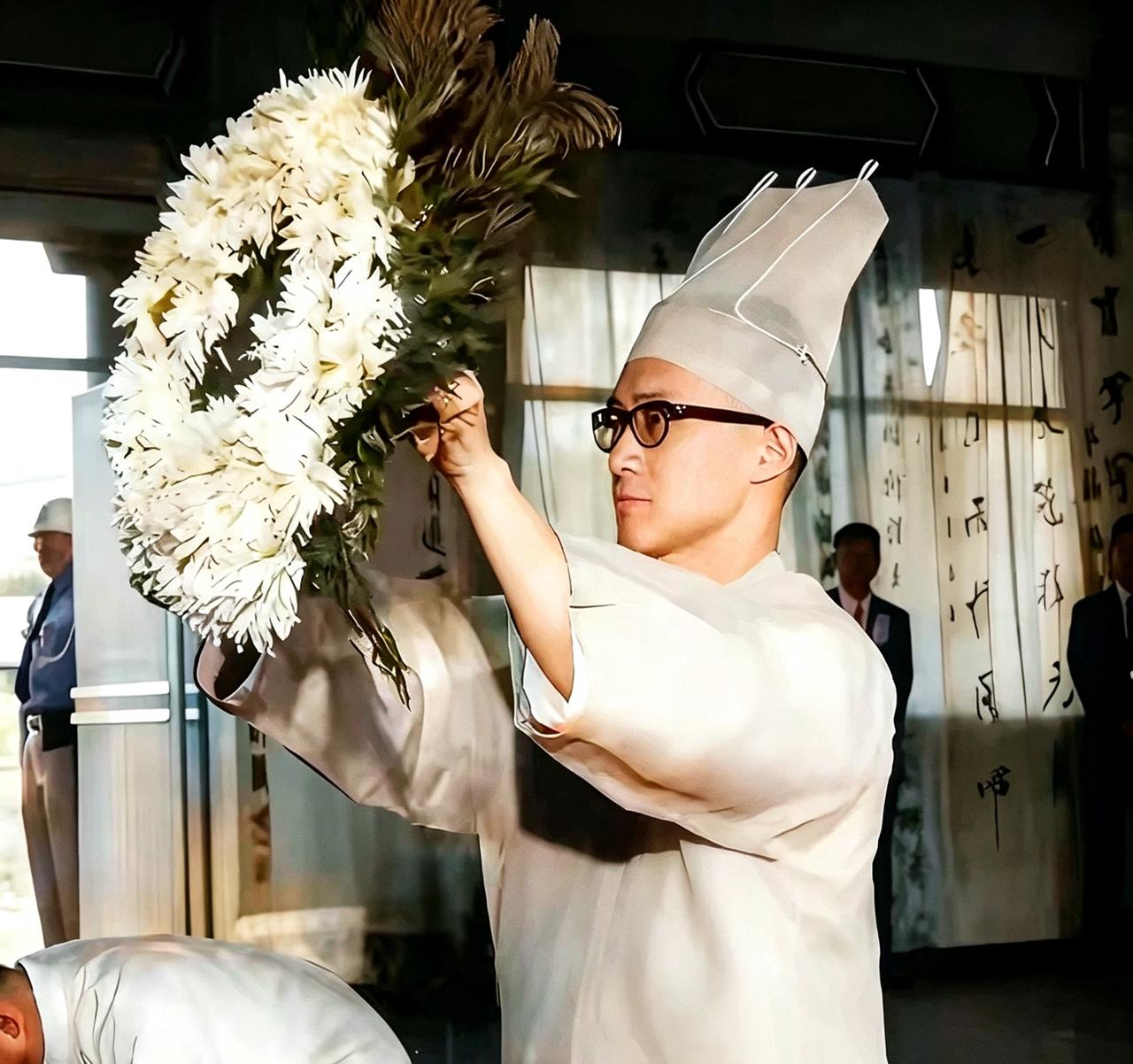 1965年陈诚葬礼，长子陈履安身着孝服，为父献花圈，一张罕见留影