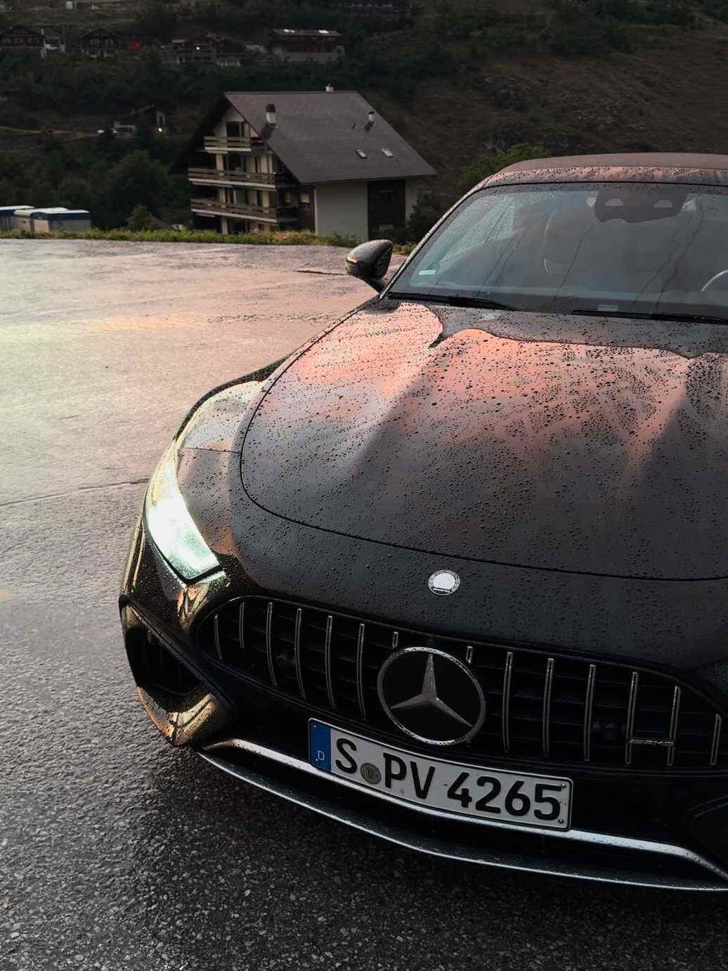 谁能拒绝在雪山公路遇见黑武士SL63，雨珠附着在车漆上，反光巨绝，远山云雾做背景